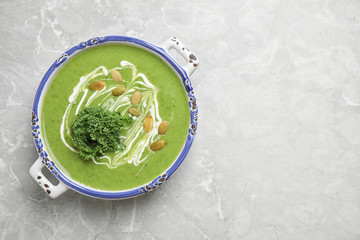 Tasty kale soup with pumpkin seeds on light grey marble table, top view. Space for text