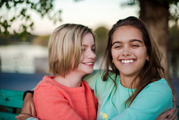 Two smiling girls. Two friends. Happy female students having fun together. Two young girls in the evening outside 
