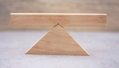 balance concept on wooden scales on a light wooden background