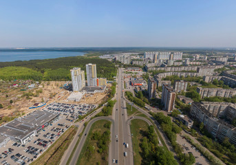 ZHBI district, Shartash lake and multi-apartment buildings under construction in Yekaterinburg city, Russia. Aerial, summer, sunny