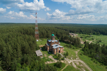 Church near the forest in Kaygorodskoe village, Russia, Sverdlovsk region. Aerial, summer, sunny