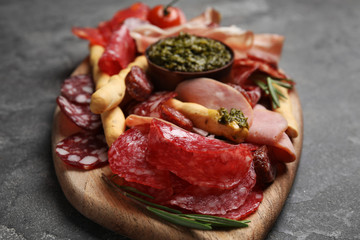 Tasty ham and other delicacies served on grey table, closeup