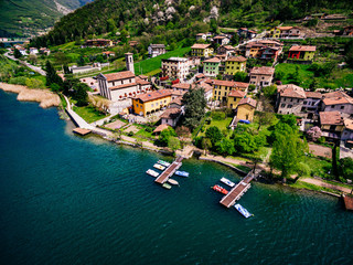 Fototapeta na wymiar Aerial view of beautiful spring landscape with Italian village by turquoise lake Endine, Italy