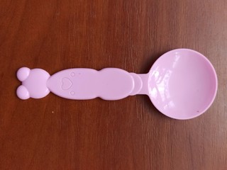 Toy spoon on wooden background