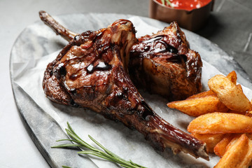 Delicious grilled ribs served on light table, closeup
