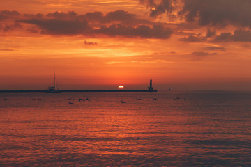 Fototapeta na wymiar Orange sunrise over water