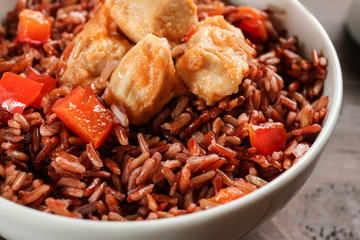 Delicious brown rice in bowl, closeup view