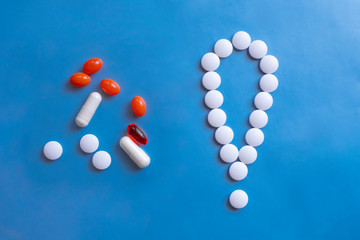 Exclamation mark white pills on blue background. Medical treatment sign & symbol. Pill icon. Attention sign symbol.
