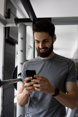 The handsome young man is working out in the gym and listening to the music