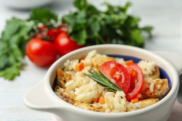 Delicious chicken risotto served in bowl, closeup