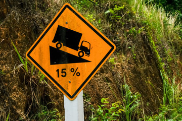 Road sign informs about descending the road. Warning of a steep descent.