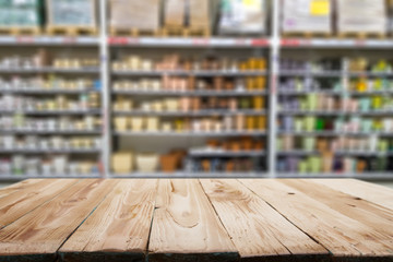 Wooden surface on blurry background of shelving with pots.