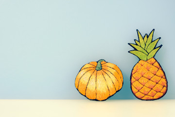 pineapple and pumpkin flat image, pastel blue background, copy space.