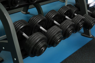 Dumbbells on rack in gym. Modern sport equipment