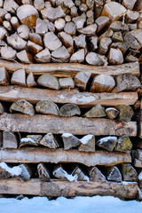 Snow on stacked wood logs.