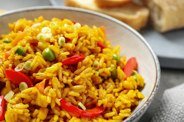 Delicious rice pilaf with vegetables in bowl, closeup