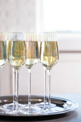 Glasses of champagne served on grey table