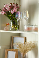 White shelving unit with glassware and different decorative elements