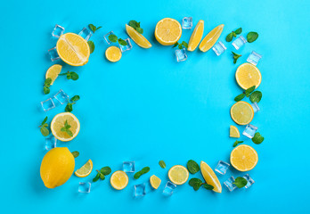 Frame made of lemon slices, mint and ice on blue background, top view with space for text. Lemonade layout