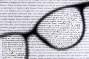 Unfocused black eyeglasses with view of sharp text through lenses. Bad eyesight concept. Eyecare concept. Reading concept. Health care concept.