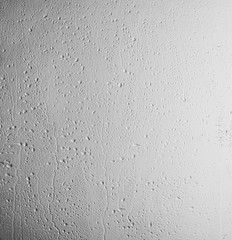 Rain drops on glass against light background