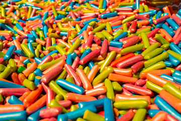 Abstract multicolored background made of many colorful sweet sticks of chewing sweets in icing. A tasty and healthy delicacy made from gelled fruit juice.