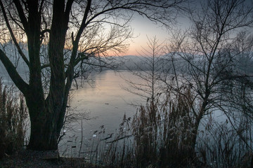 beautiful view on a frozen lake in winter season in beautiful sunset and mountains