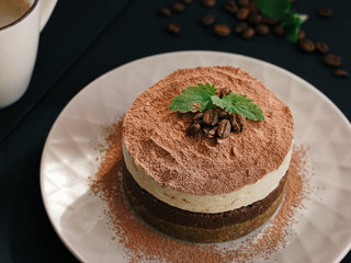  Tiramisu on a beige plate. Coffee with cinnamon. Raw dessert