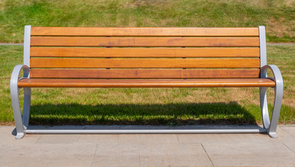Wooden bench on grass background.