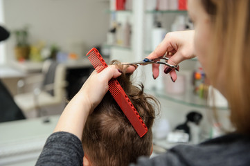 Close up picture of boy/child kid, sitting in the hairdressing salon