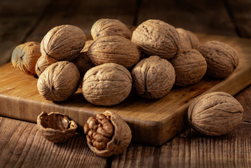 Kernels of walnuts on a dark countertops with a dark background on the board, vintage.