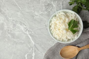Bowl with tasty cooked rice on light grey marble table, flat lay. Space for text