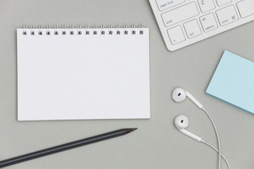Blank spiral notebook and pencil on gray background. Top view with copy space for input the text. 