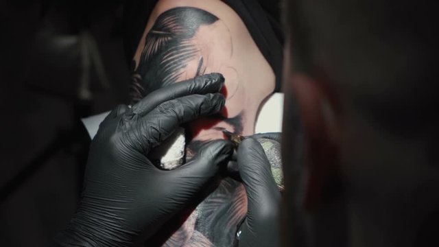 Video of man doing dark tattoo of snake