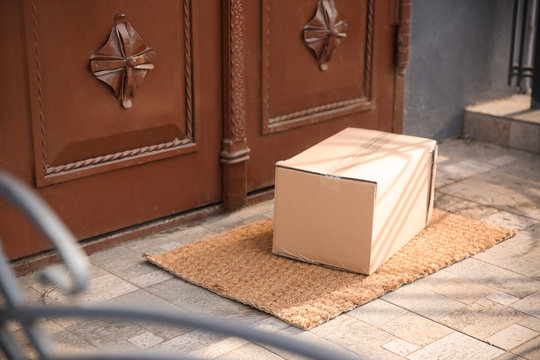 Delivered parcel on door mat near entrance