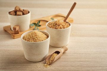 Bowls with different types of brown sugar on wooden table