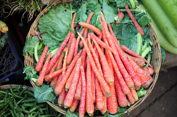 Carrots on the market in a basket close-up. Asian street market of vegetables, products of local Indian farmers.