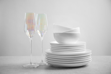 Set of clean dishes and glasses on light grey table