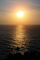 Obraz premium Calm sea in mysterious light of setting sun, a haze over the horizon. Sunset over the sea, sunlight reflected from the surface of water.