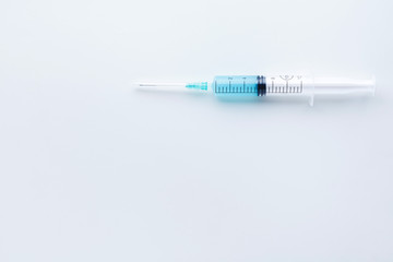 Obraz premium Single syringe filled with light blue liquid