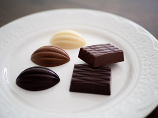 白いお皿の上に並べられた様々な種類のチョコレート
