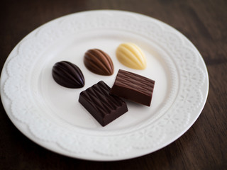 白いお皿の上に並べられた様々な種類のチョコレート