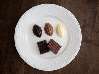 白いお皿の上に並べられた様々な種類のチョコレート
