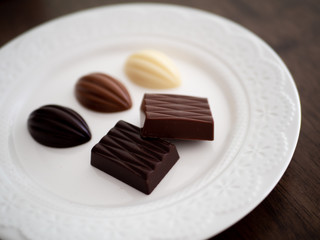 白いお皿の上に並べられた様々な種類のチョコレート
