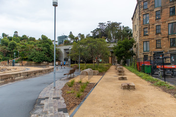 People walking on a walking track in the park in front of an old building