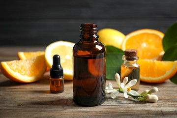 Bottles of citrus essential oil on wooden table