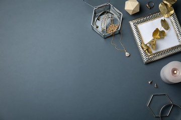 Flat lay composition with stylish accessories and decor elements on dark grey background. Space for text