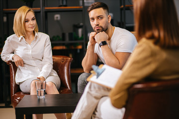 disagreement, people relationships concept. married couple discussing problems at therapy with psychologist, sit attentively listen to irritated give advice, support, possible solutions to problems