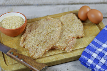 escalope de volaille panées sur une planche à découper