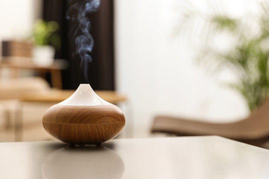 Aroma oil diffuser on light table at home, space for text. Air freshener